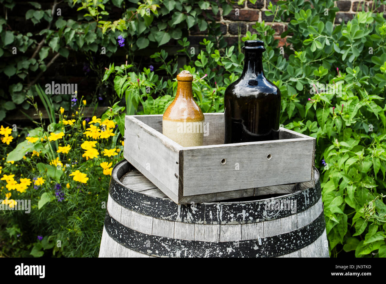 Vetro e ceramica di bottiglie in una scatola come decorazione in un giardino. Foto Stock