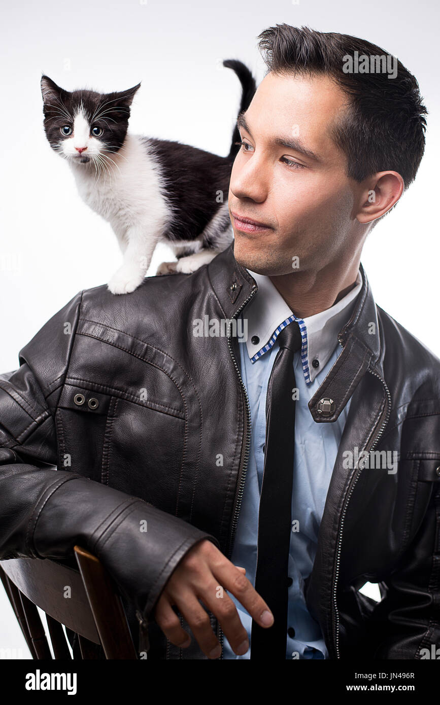 Ben vestito giovane uomo della modellazione di un gattino seduto sulle sue spalle, Maine, Stati Uniti d'America Foto Stock