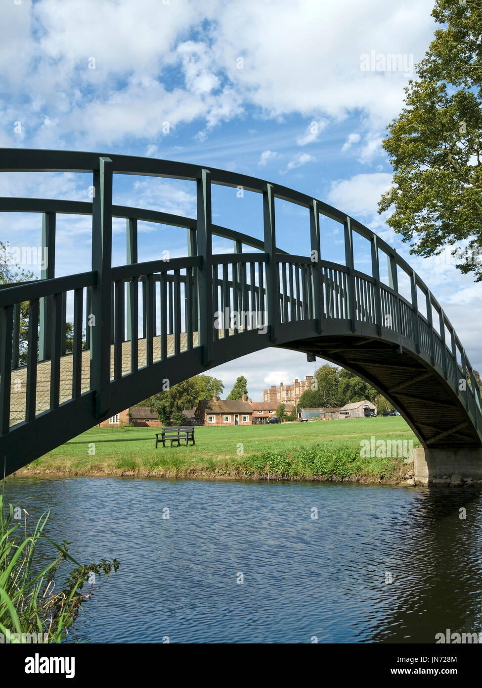 Smart nuovo, unico arco in legno passerella pedonale oltre alla peschiera in motivi di Doddington Hall Estate, Lincolnshire, England, Regno Unito Foto Stock