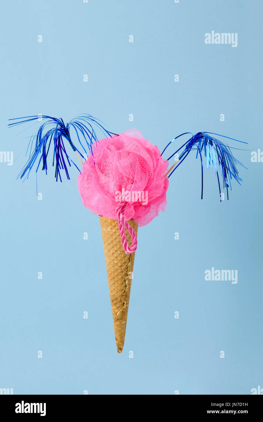 Un cono gelato il cui convogliatore è sostituito da una plastica rosa spugna Luffa. Composizione Fotografica divertente e bizzarra. Divertimento, minimale e surreale colore Foto Stock