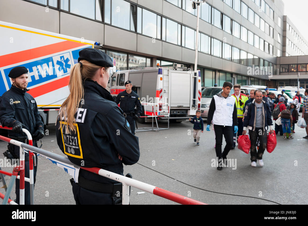Monaco di Baviera, Germania - Settembre 10th, 2015: Polizia Tedesca e aiutanti sono in attesa per la successiva coda di rifugiati dalla Siria, Afghanistan e i Balcani. Foto Stock