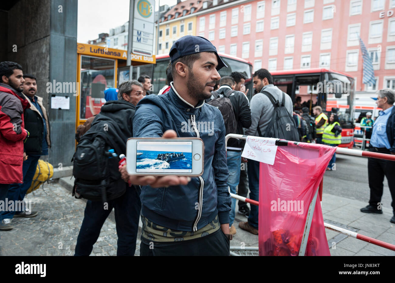 Monaco di Baviera, Germania - 7 Settembre 2015: rifugiato dall' Afghanistan dimostra le immagini della sua via di fuga su una barca. Molti rifugiati fuggono sul mare in Europa Foto Stock