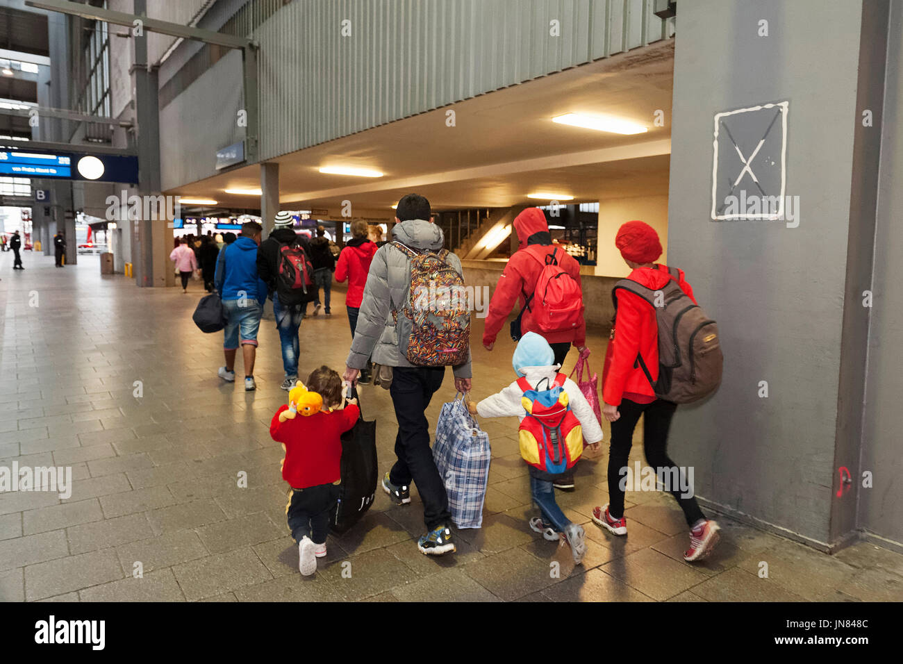 Monaco di Baviera, Germania - 9 Settembre 2015: una giovane famiglia dalla Siria hopping su un treno alla stazione centrale di Monaco di Baviera. I rifugiati che chiedono asilo. Foto Stock