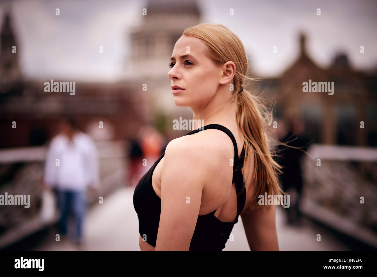 Una giovane donna entra in pausa e trova il suo focus durante una corsa sulla passerella del Millennio Foto Stock