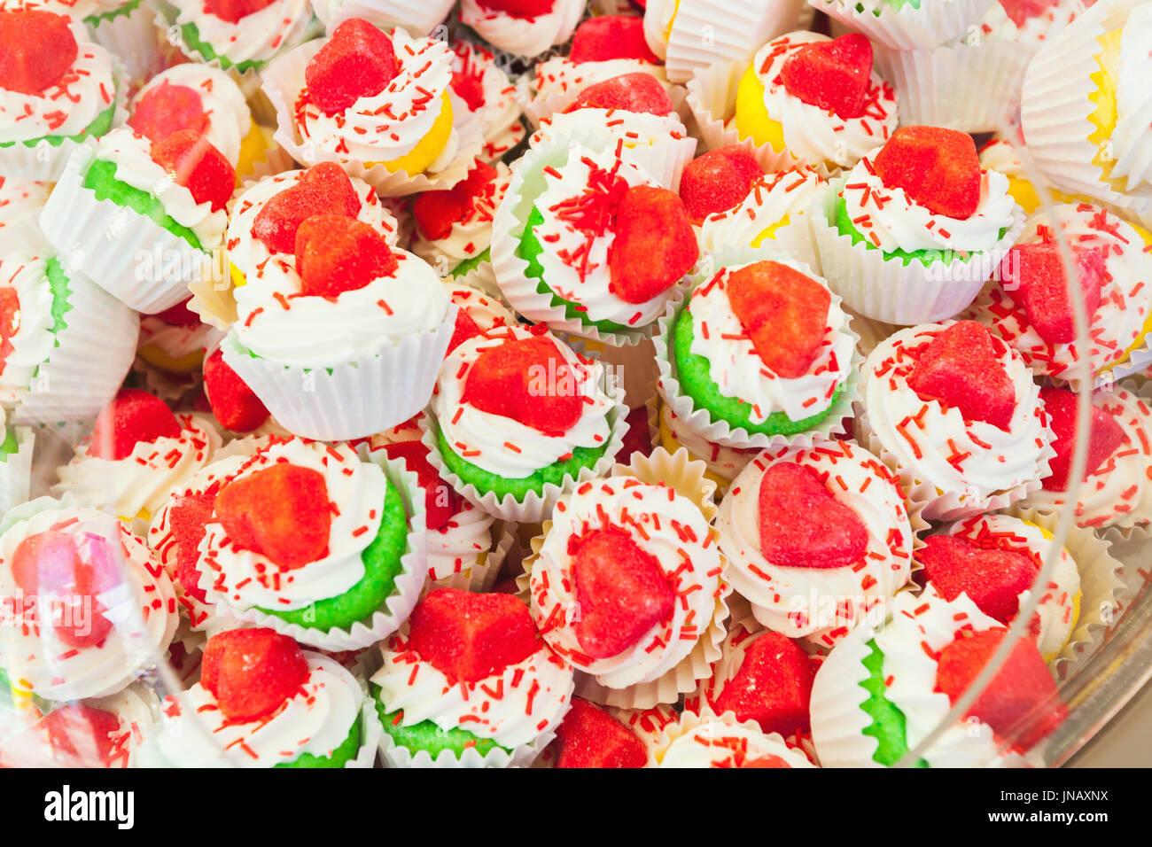 Pila di colorate torte fatte in casa in carta cesti con cuore decorazione sagomato Foto Stock