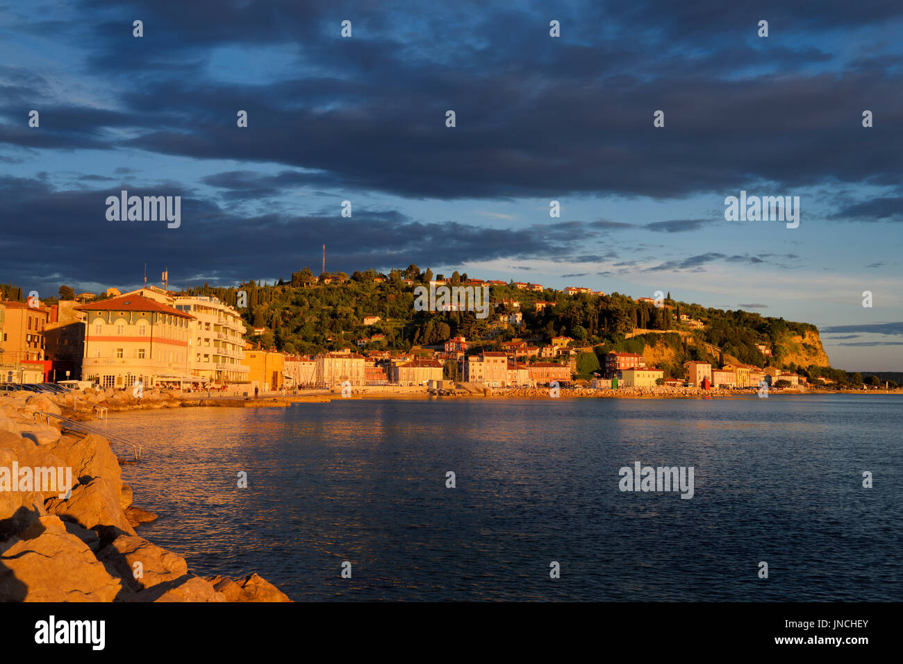 Luce rossa al tramonto sul mare Adriatico costa a Pirano Slovenia porto e collina che affaccia sulla città vecchia Foto Stock