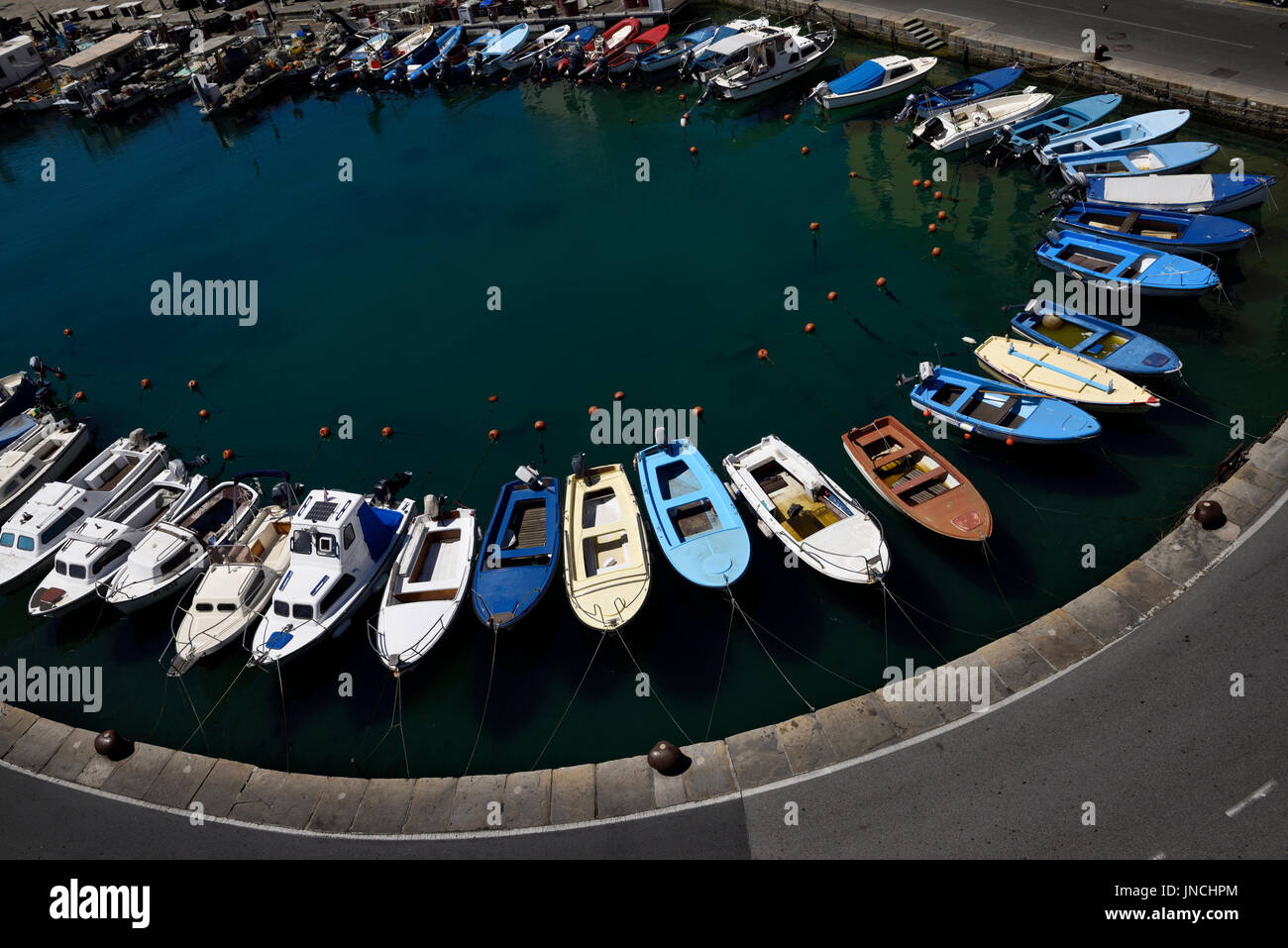 Il ferro di cavallo andamento curvo di barche ormeggiate al porto interno di pirano Slovenia sulla costa sul Mare Adriatico con acqua verde Foto Stock