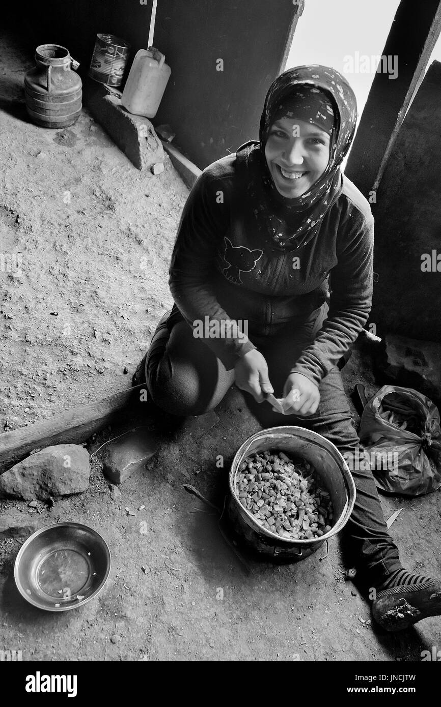 Giovani palestinesi beduino donne cuochi la cena in una tenda, ad est di Gerusalemme, West Bank, Dicembre 10, 2010. I beduini sostenere uno stile di vita nomade Foto Stock