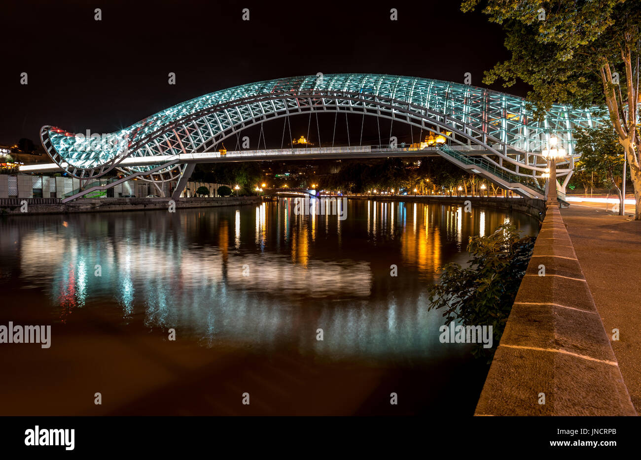 Vista notturna del ponte di pace sul fiume Kura, Tbilisi, Georgia Foto Stock