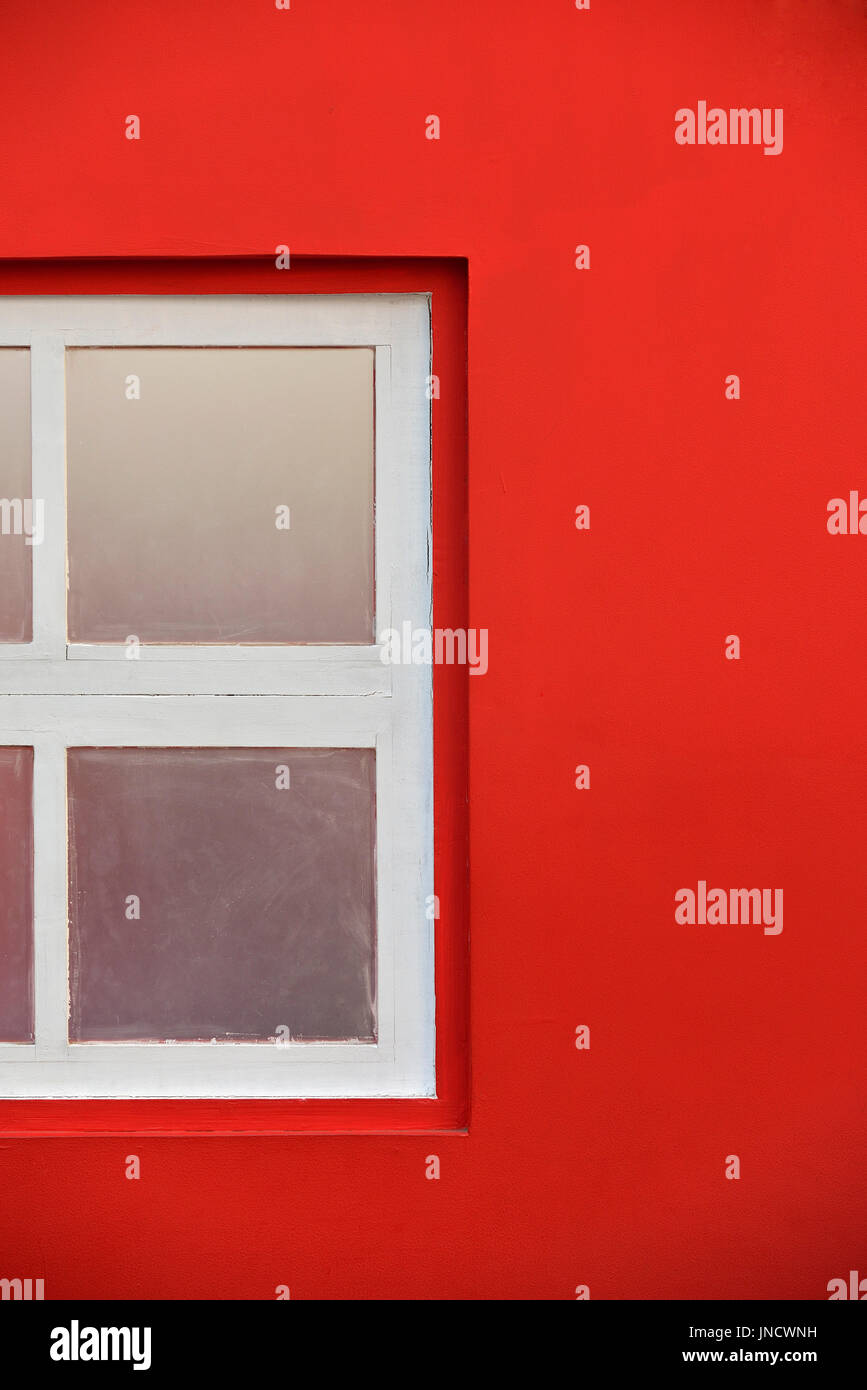 In legno bianco con finestra di vetro nella Parete Rossa Shot Outdoor Foto Stock