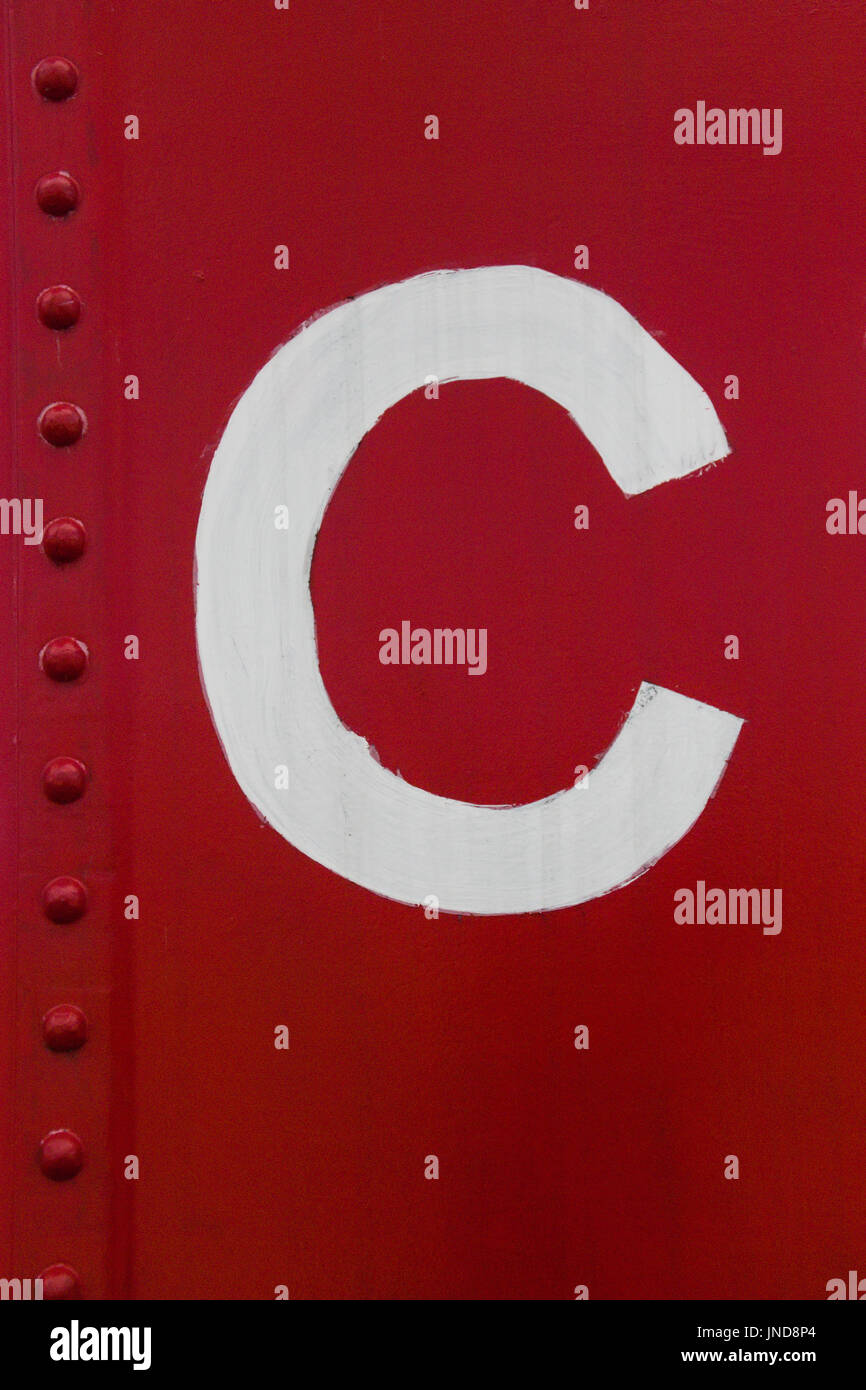 White lettera maiuscola C stampata su un colore rosso brillante vagoni ferroviari Foto Stock
