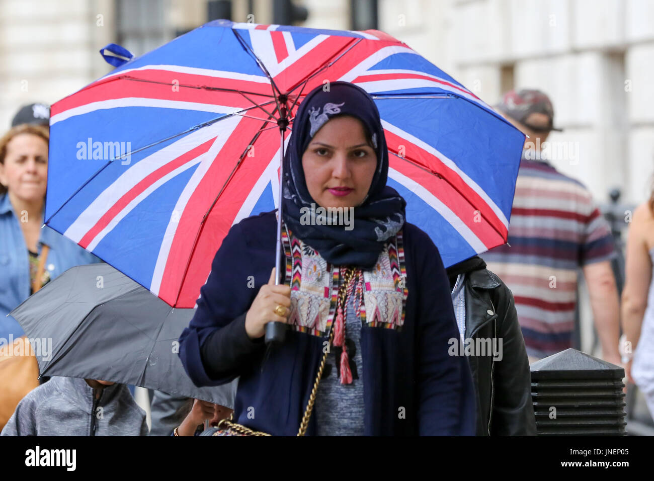Whitehall. Westminster. Londra, Regno Unito. Il 30 luglio, 2017. I turisti riparo dalla pioggia in Whitehall, Westminster. Credito: Dinendra Haria/Alamy Live News Foto Stock