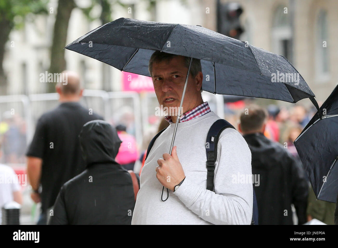 Whitehall. Westminster. Londra, Regno Unito. Il 30 luglio, 2017. I turisti riparo dalla pioggia in Whitehall, Westminster. Credito: Dinendra Haria/Alamy Live News Foto Stock