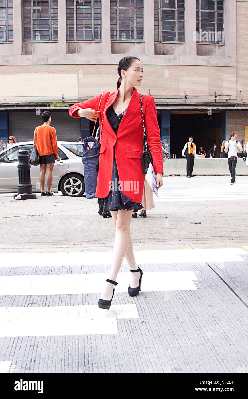 Modello off duty : asiatici modello fashion street style indossando un rosso blazer e mantello attraversando la strada durante la settimana della moda di New York Foto Stock