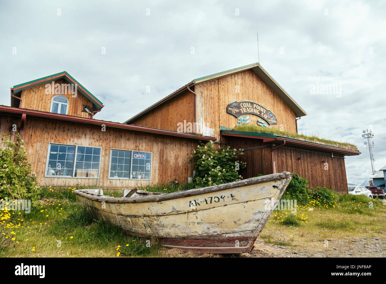 Vecchia barca davanti a un edificio, Carbone punto Trading Co, Homer Spit, Omero, Penisola di Kenai, Alaska, STATI UNITI D'AMERICA Foto Stock