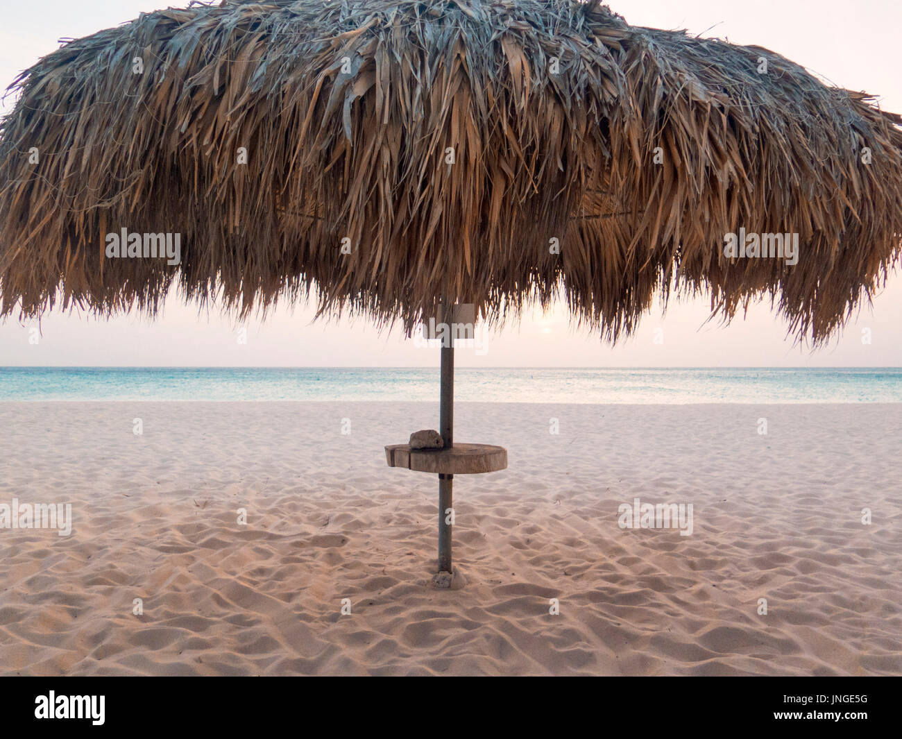 Tramonto sotto la palapa sulla spiaggia di Aruba Foto Stock