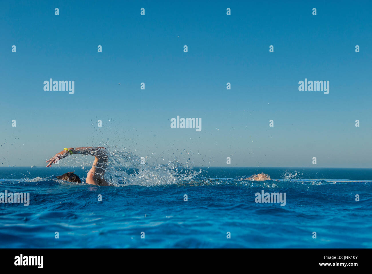 Un ragazzo adolescente treni in una piscina infinity Foto Stock