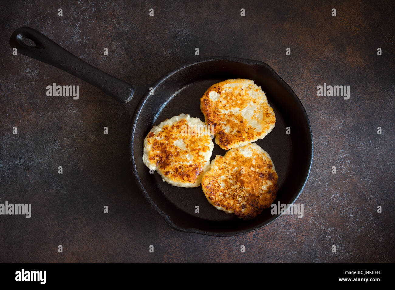 In casa rustico cagliata frittelle in ghisa pan per la colazione, in stile country. Rustico sano cibo, cottage cheese pancakes. Foto Stock