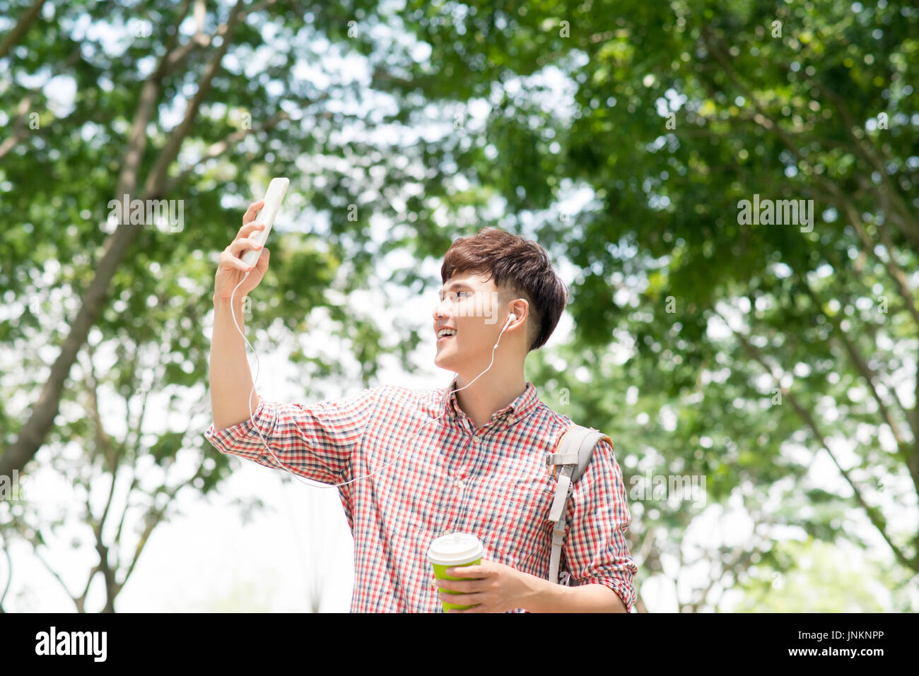 Bel giovane uomo asiatico guardare al cellulare Foto Stock