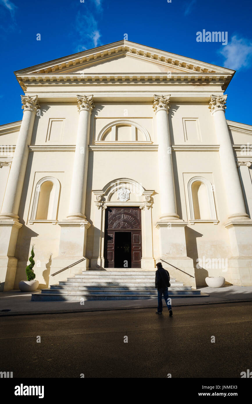 Uomo chiesa buio luce, vista posteriore di un uomo che emerge dall'ombra scura quando si avvicina ad una chiesa a Sassari, nel nord della Sardegna. Foto Stock