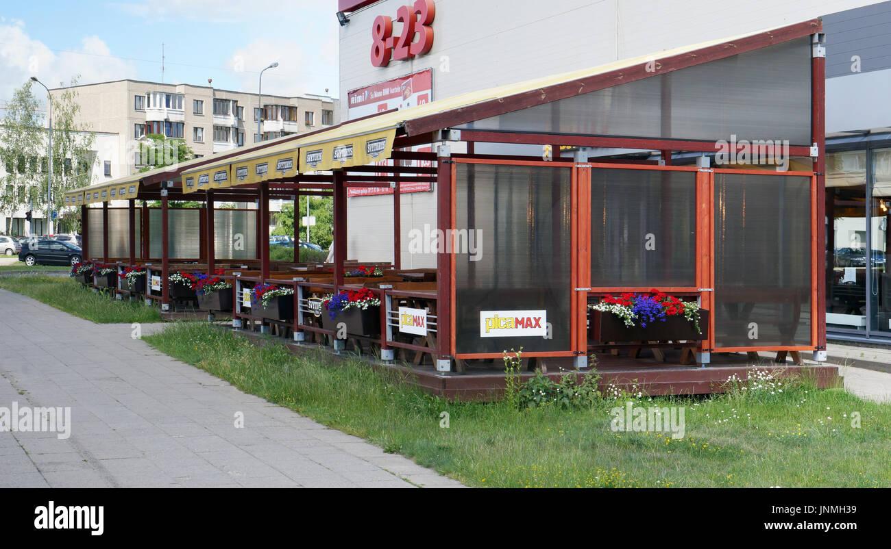 VILNIUS Lituania - Luglio 06, 2017: Un padiglione in legno con fiori e tabelle vicino PicaMax pizzeria. Nelle vicinanze vi è un grande negozio del marchio commerciale Foto Stock