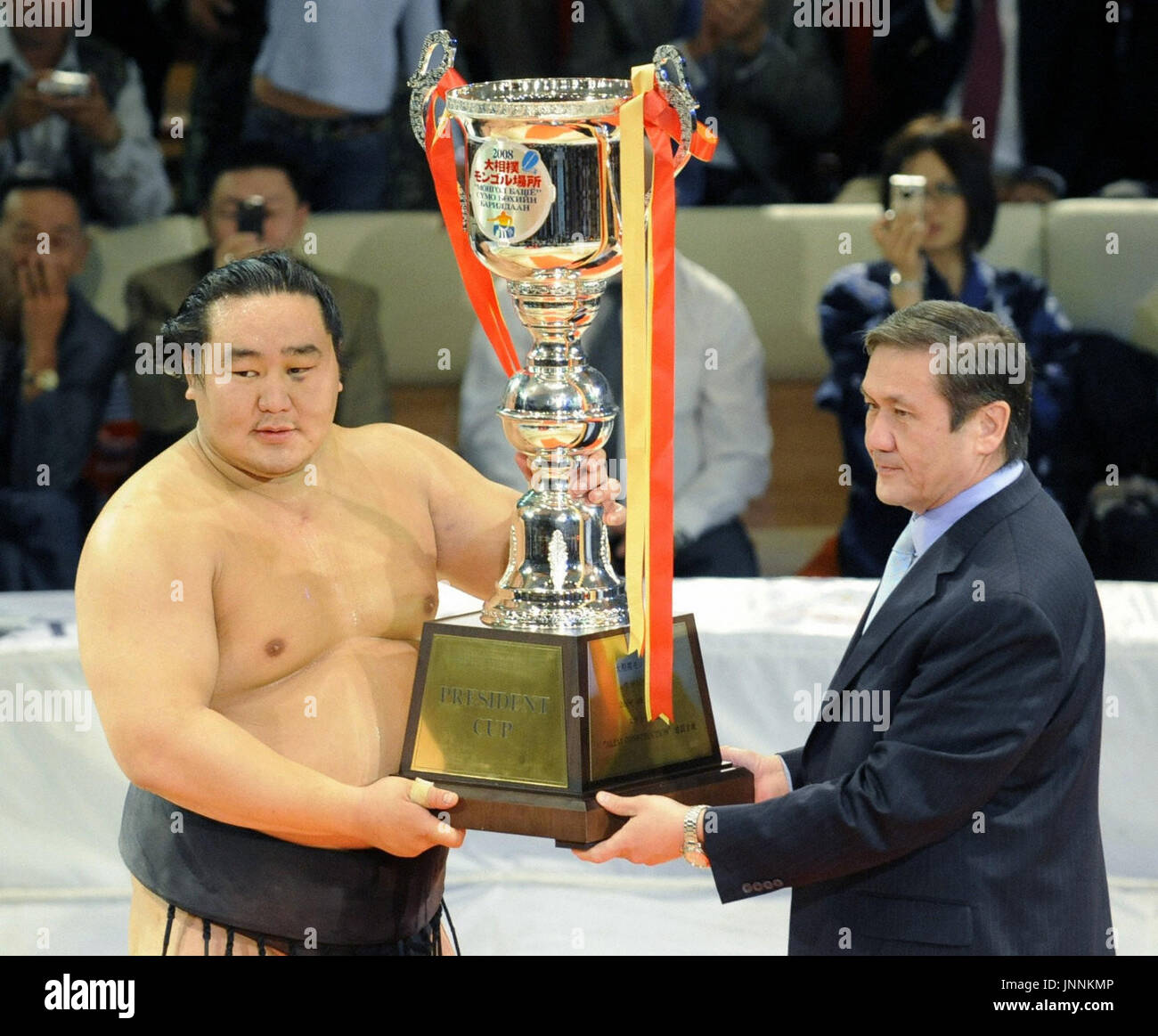 ULAN BATOR, Mongolia - Yokozuna Asashoryu (L) è presentato dal Presidente della Mongolia Nambaryn Enkhbayar (R) con un trofeo per vincere il titolo assoluto nel primo-mai sumo exhibition tour della Mongolia in Ulan Bator che il 28 agosto. (Kyodo) Foto Stock