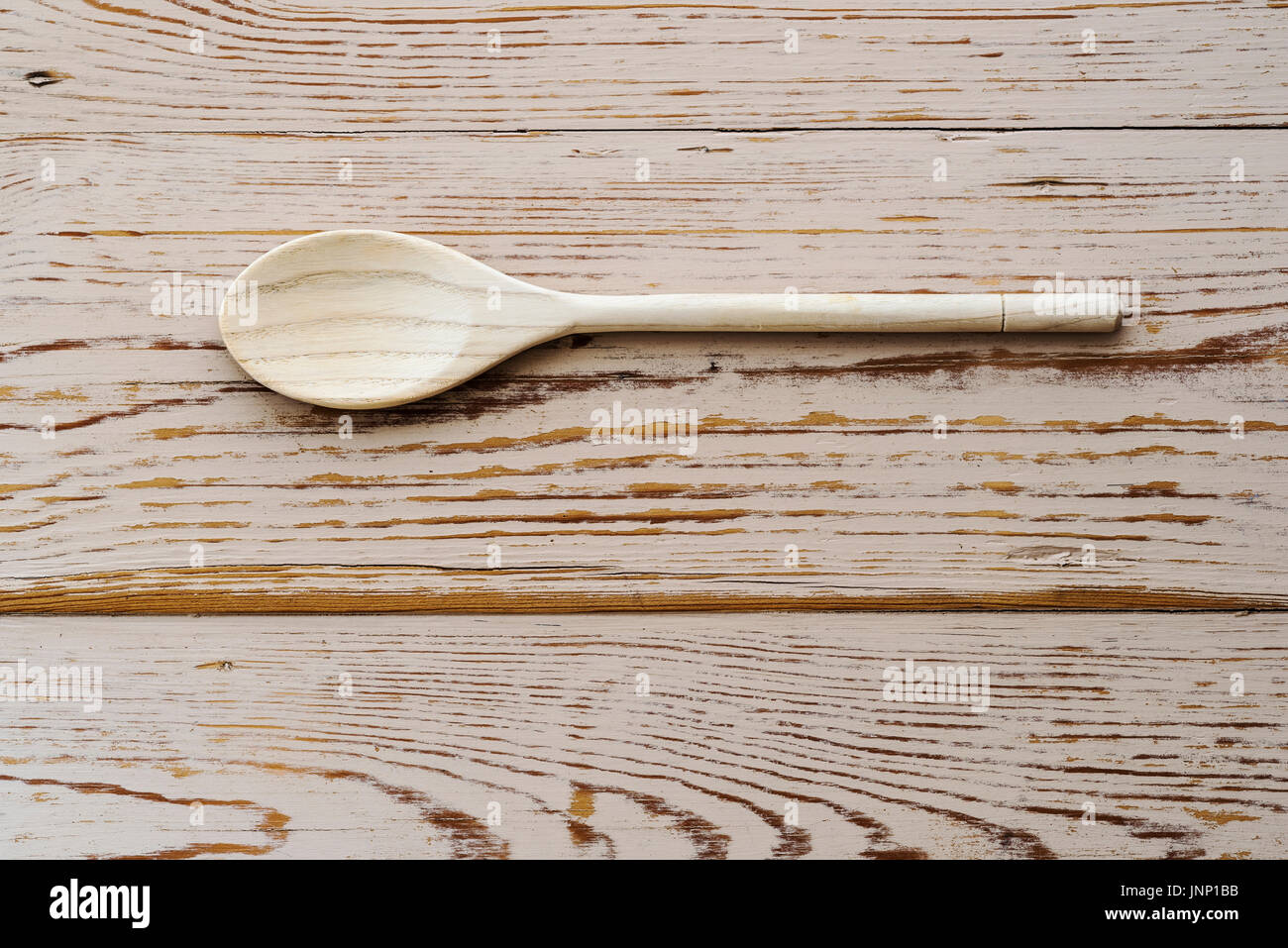 Scatto dall'alto di un cucchiaio di legno su distressed tavolo. Foto Stock