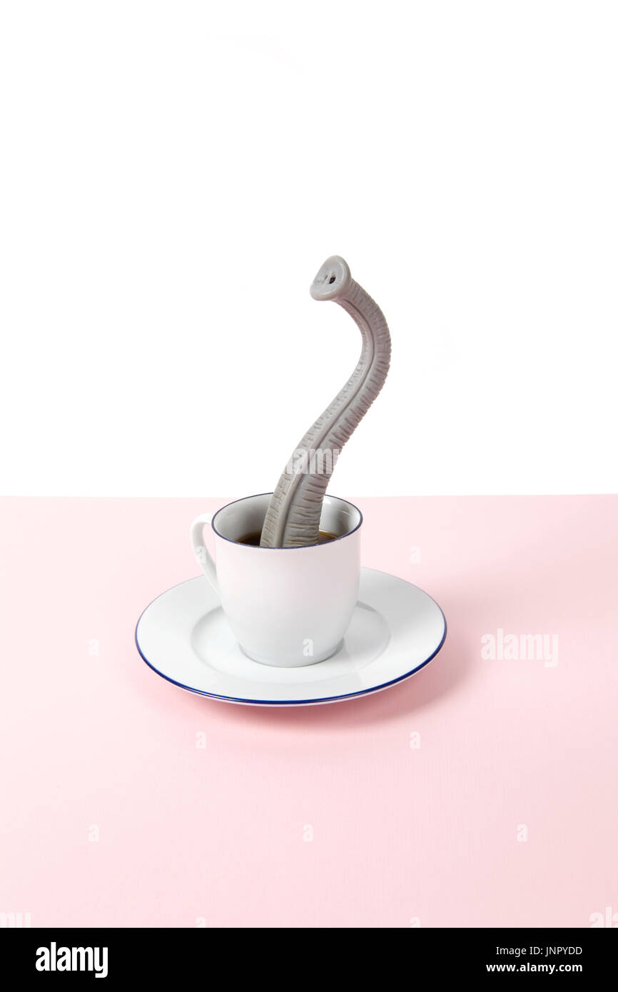 Una proboscide emergente da un design di piccole dimensioni tazza di caffè come se egli fosse nascosto. Il minimo divertente e stravagante design vita ancora fotografia Foto Stock