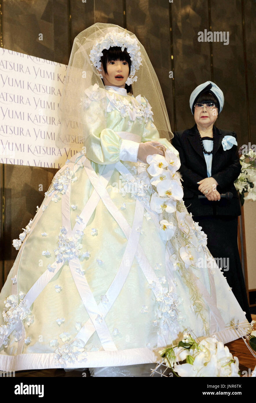 OSAKA, Giappone - Un HRP-4C (L), un ''femminile "' robot umanoide sviluppato da un istituto nazionale, e ben noto nuziale giapponese stilista Yumi Katsura (R) posa per fotografi in luglio 22. Il robot ha camminato su una passerella come un modello per abiti da sposa progettati da Katsura nel suo spettacolo presso un hotel di Osaka il 22 luglio. (Kyodo) Foto Stock