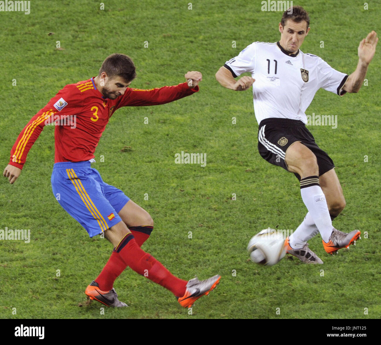 DURBAN, Sud Africa - Spagna defender GERARD PIQUE (L) germogli passato Germania scontrino Miroslav KLOSE durante una World Cup Semifinal a Durban Stadium di Durban, in Sud Africa il 7 luglio 2010. La Spagna ha vinto 1-0 per avanzare verso la finale contro i Paesi Bassi. (Kyodo) Foto Stock