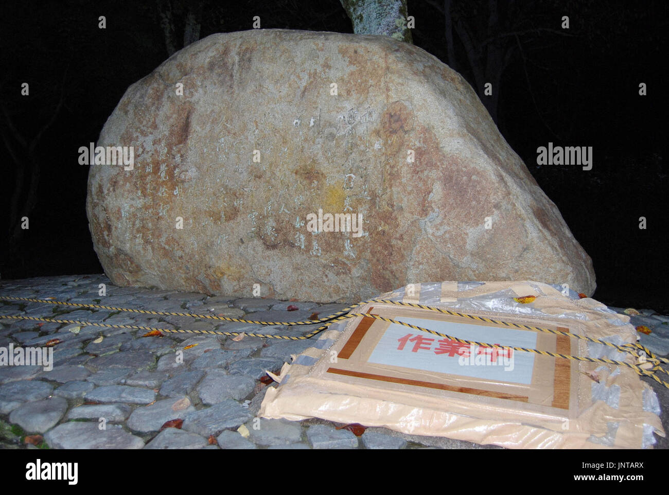 KYOTO, Giappone - una sezione contaminata da vernice gialla è coperta dal cartone (anteriore R) in corrispondenza di una poetica compressa della fine il Premier cinese Zhou Enlai ad Arashiyama Park a Kyoto il 7 settembre 30, 2010. Il monumento è stato istituito nel 1979 per commemorare un accordo bilaterale per il trattato di pace. (Kyodo) Foto Stock