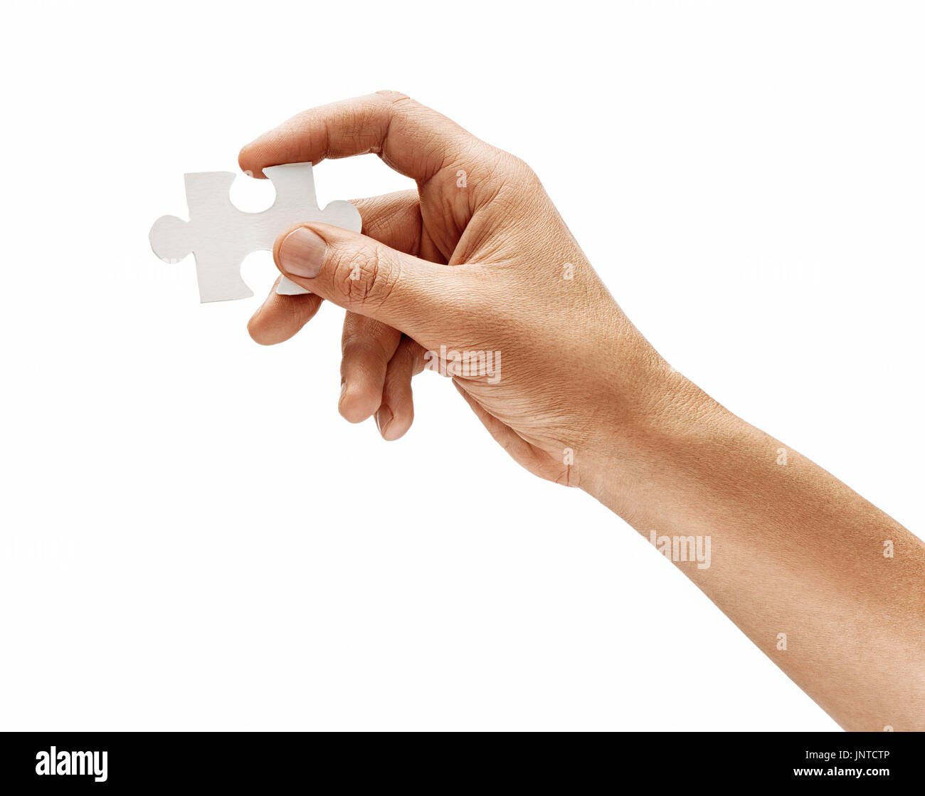 Mano d'uomo con un puzzle elemento isolato su sfondo bianco. Close up. Alta risoluzione prodotto Foto Stock
