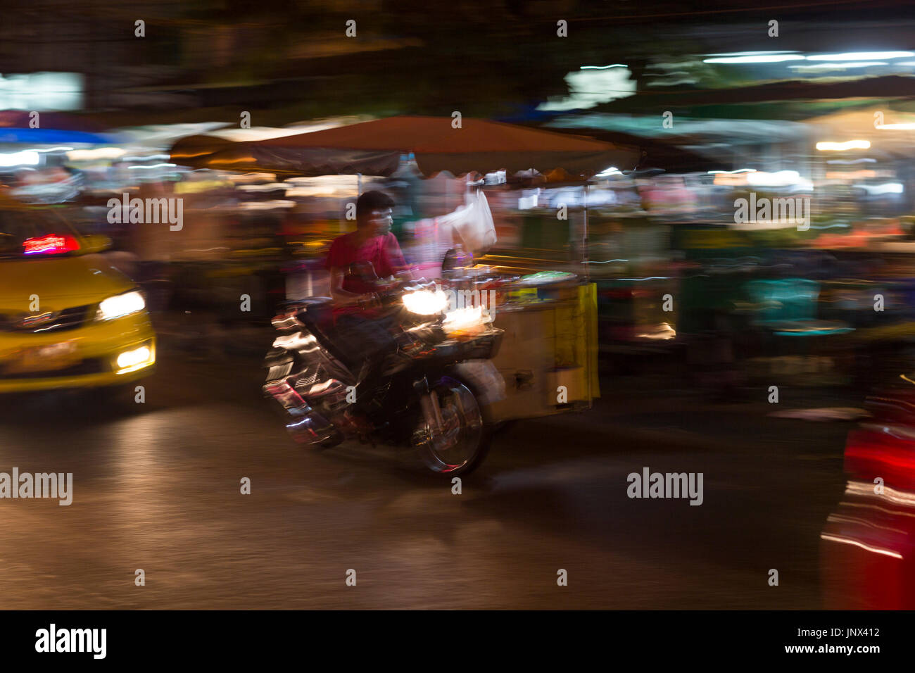 Bangkok, Tailandia - 18 Febbraio 2015: Moto e taxi con motion blur in notturna a Rattanakosin, la sezione storica di Bangkok. Il tuk-tuk è uno dei più comuni modalità di trasporto in Bangkok. Foto Stock