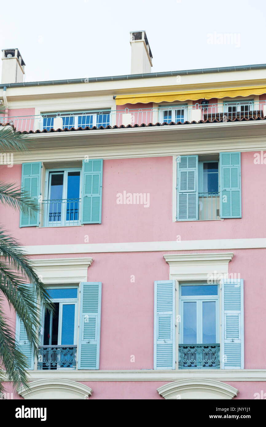 Menton, Alpi Marittime, Francia - 10 Ottobre 2015: tipici edifici di appartamenti in colori pastello con persiane alle finestre in Menton, a sud est della Francia. Foto Stock