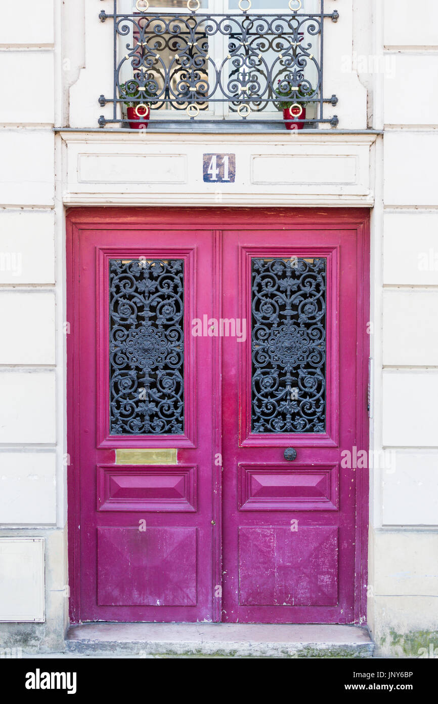 Parigi, Francia - 29 Febbraio 2016: profonda porta rosa nero con griglia di ferro battuto a Parigi, Francia. Foto Stock