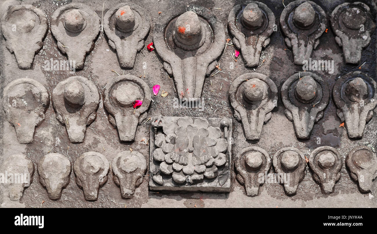 Una serie di piccole Shiva linga scolpiti nel ghats a Varanasi Foto Stock