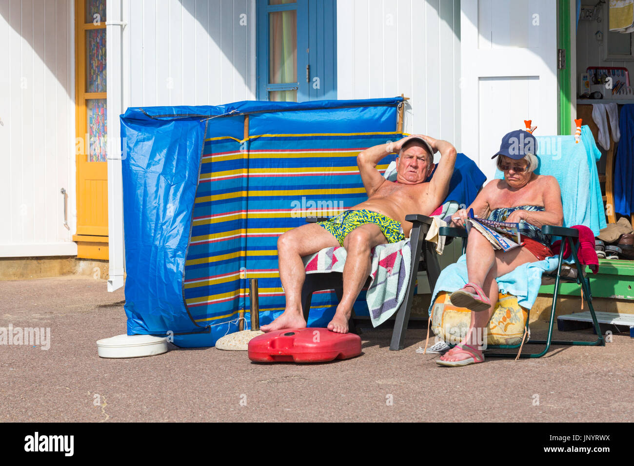 Bournemouth Dorset, Regno Unito. 31 Luglio, 2017. Regno Unito: meteo dopo un weekend di miste di tempo caldo e soleggiato per iniziare la nuova settimana, come i visitatori in testa al mare per rendere la maggior parte del sole. Coppia matura di relax al sole presso il Beach Hut. Credito: Carolyn Jenkins/Alamy Live News Foto Stock