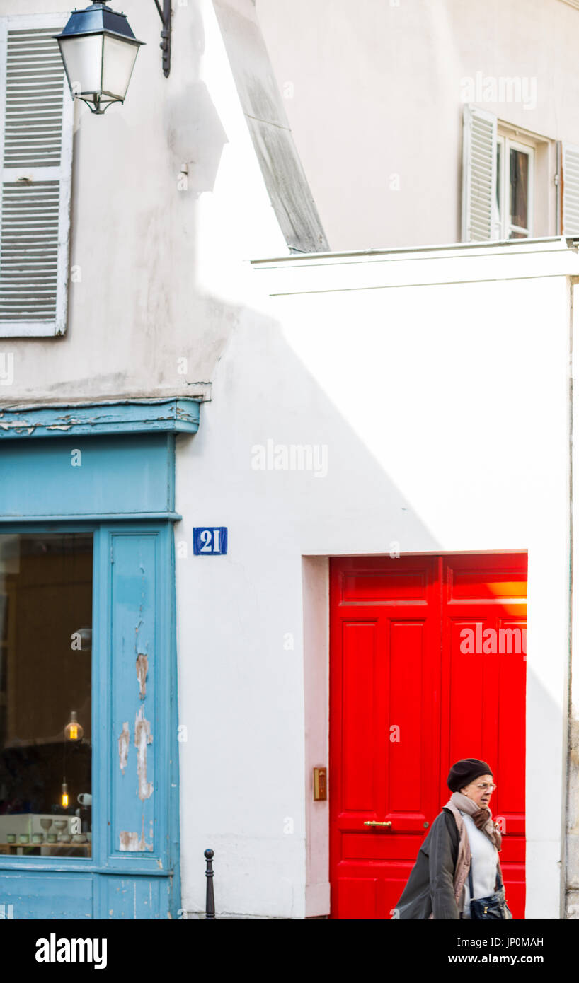 Parigi, Francia - 2 Marzo 2016: Donna oltrepassando vecchi edifici su rue du Petit Musc nel Marais, Parigi con colorati di porte e finestre Foto Stock