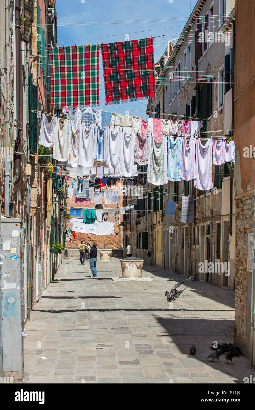 Venezia, Italia - 26 Aprile 2012: vestiti ad asciugare su clotheslines infilate tra gli edifici nel quartiere di Castello di Venezia. Foto Stock