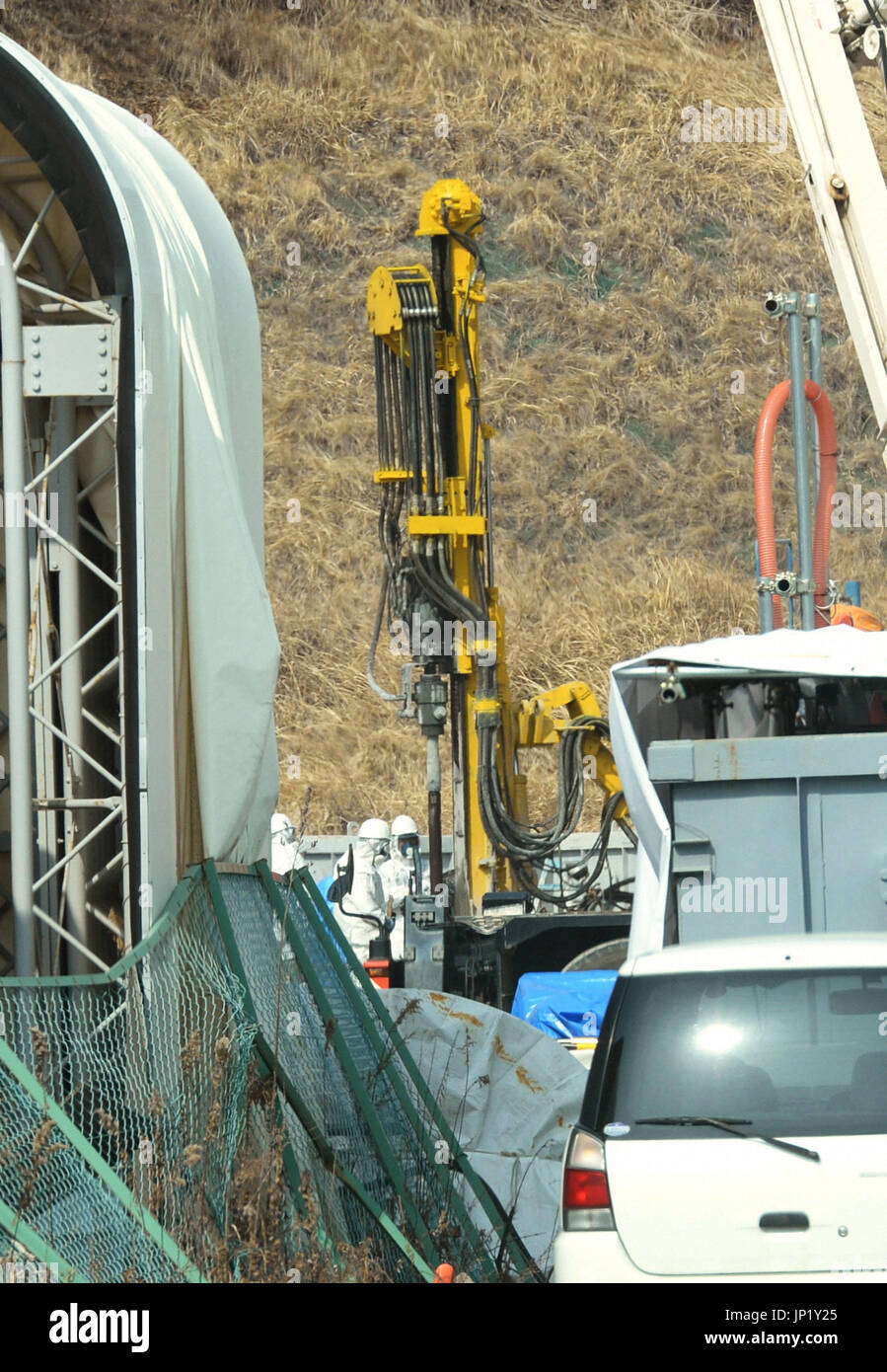 TOKYO, Giappone - Lavoratori scavare un foro per inserire un condotto di congelare il terreno per un test di verifica sotterranea di un muro di ghiaccio per bloccare le acque sotterranee che fluisce in strutture a Fukushima Daiichi centrale nucleare a Fukushima Prefettura nel febbraio 26, 2014. Piscina (foto) (Kyodo) Foto Stock