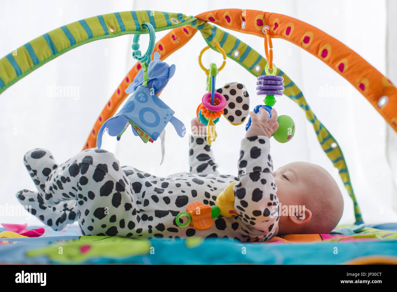 Happy baby boy sorridente sul playmat Foto Stock