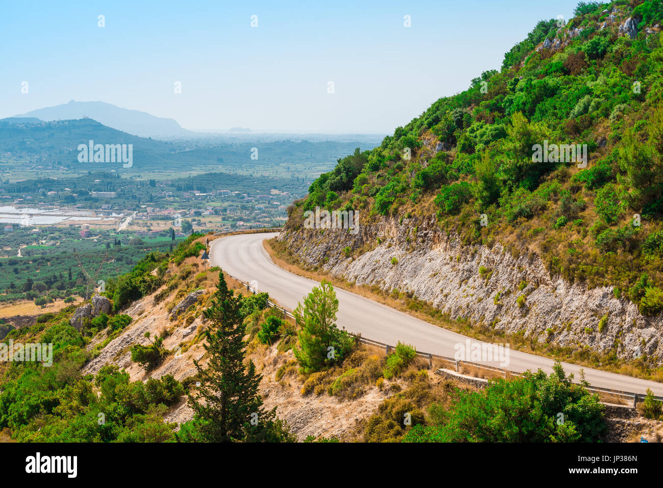 Bella strada tortuosa in montagna. Viaggio estivo dello sfondo. Paesaggio di montagna. Panorama della città nella valle di montagna Foto Stock