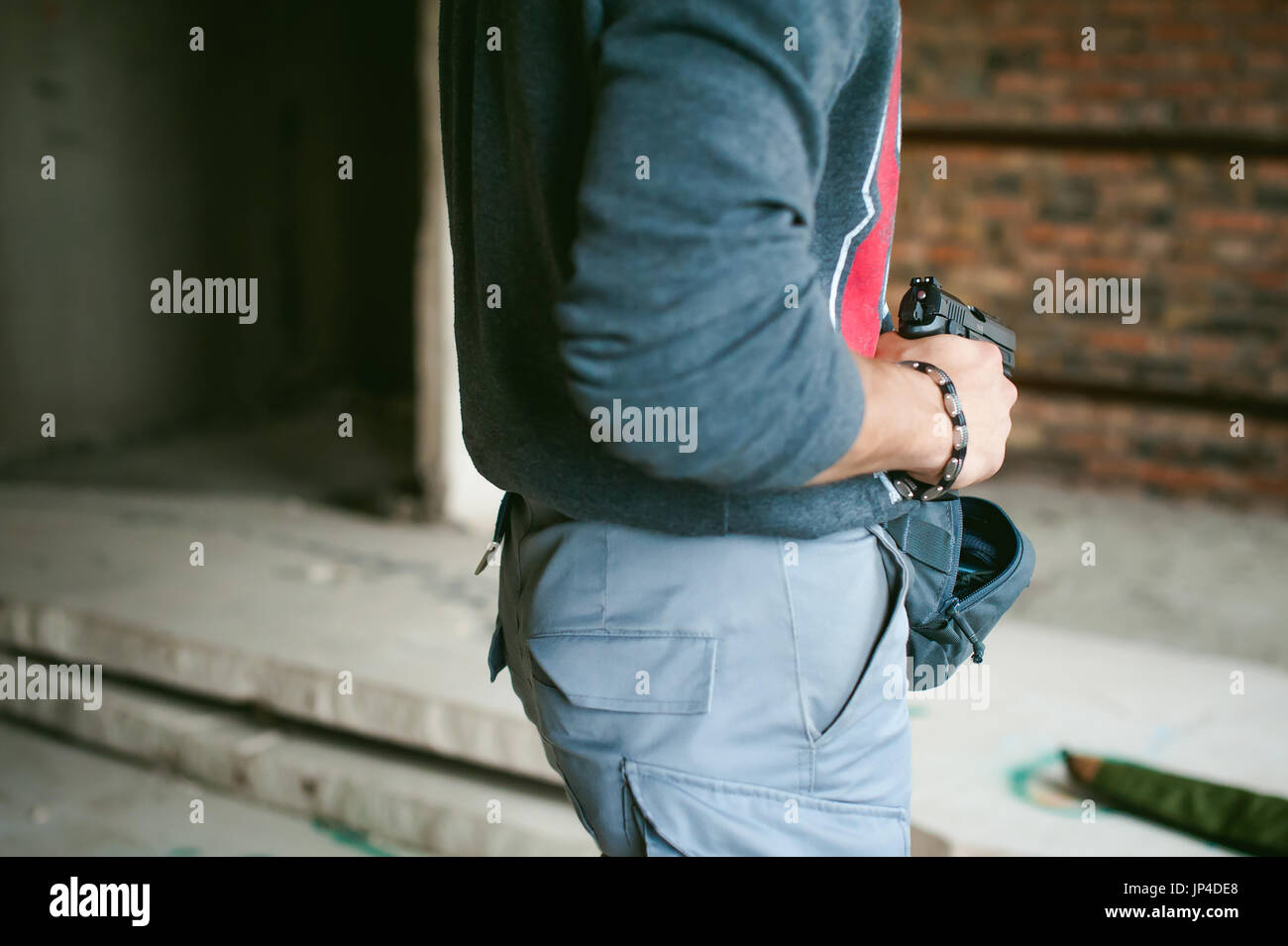 Uomo tira una pistola fuori della sua borsa, tenendolo in mano Foto Stock