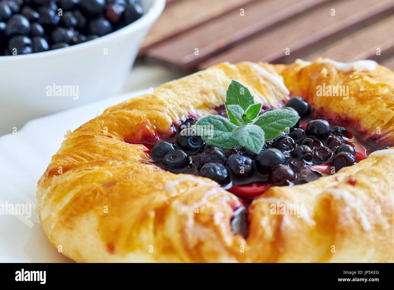 Pasta sfoglia torta ricoperta con mirtillo Frutta sciroppata, servita su sfondo di legno Foto Stock