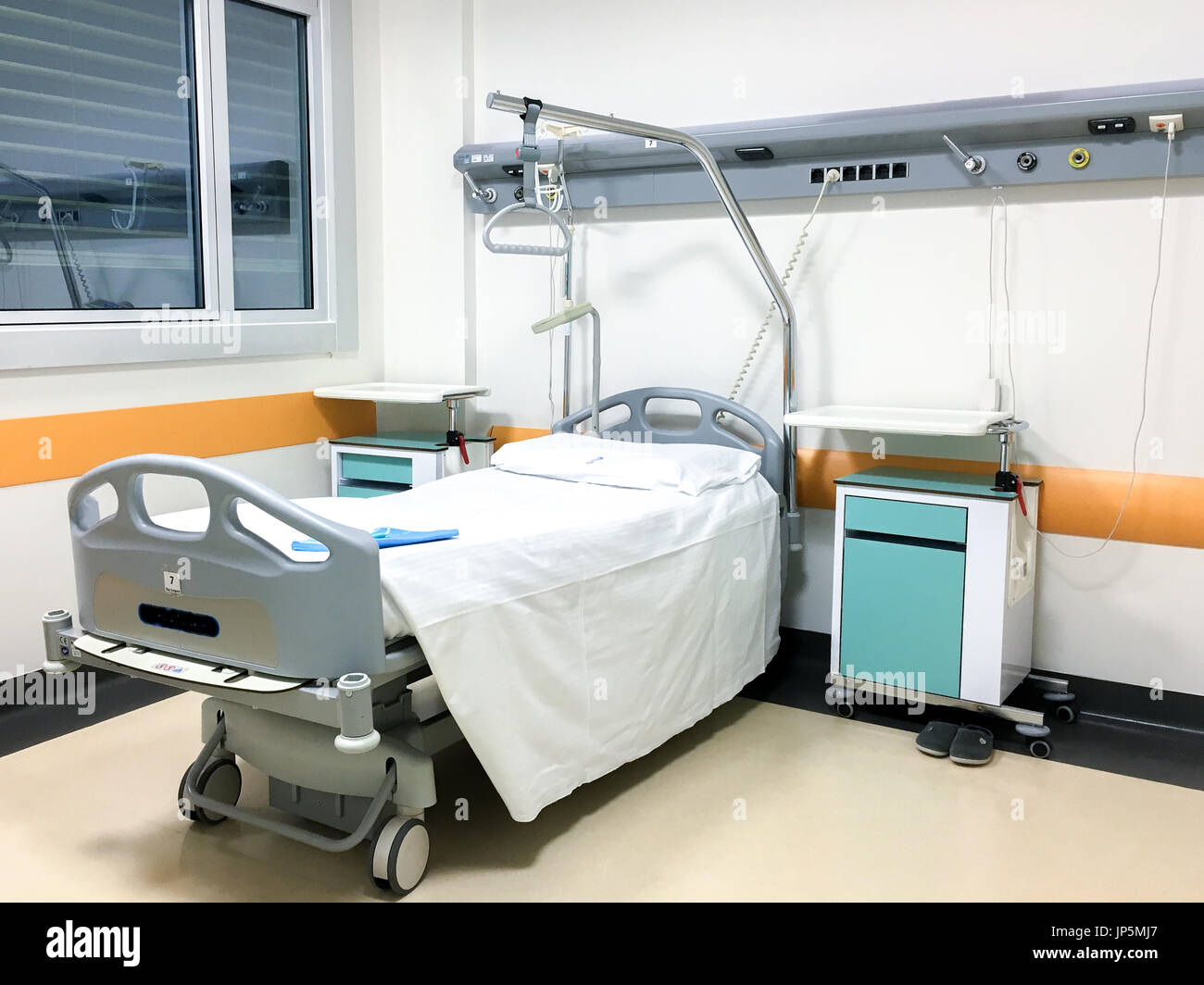 Interno della stanza di ospedale con letto singolo e apparecchiature mediche. Foto Stock