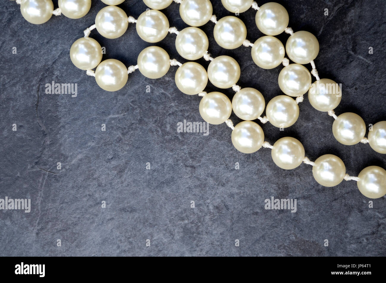 Fake perle su uno sfondo grigio Foto Stock