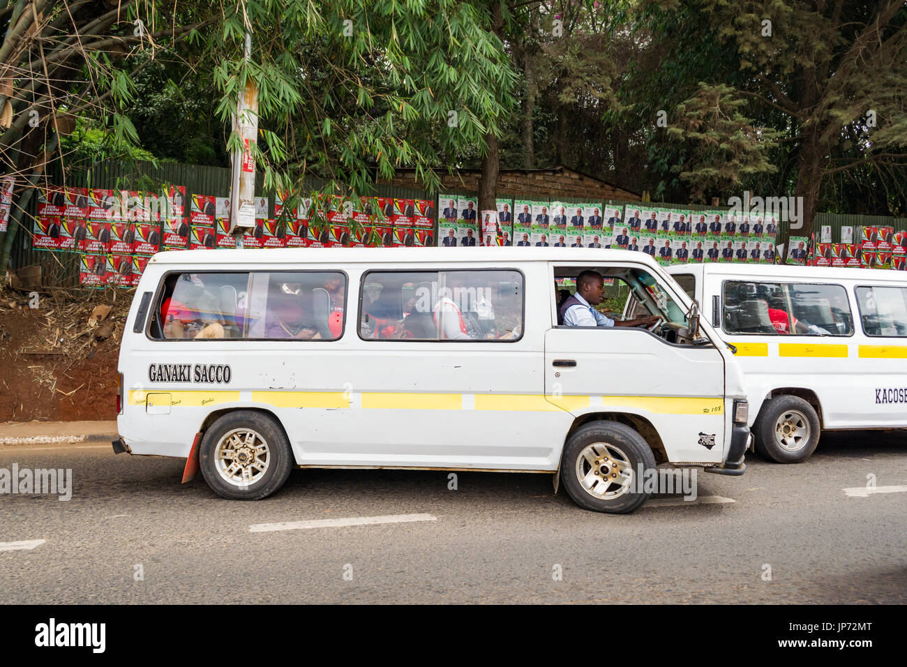 Un Matatu Van con passeggeri nella parte anteriore della parete di una elezione poster, Nairobi, Kenia Foto Stock