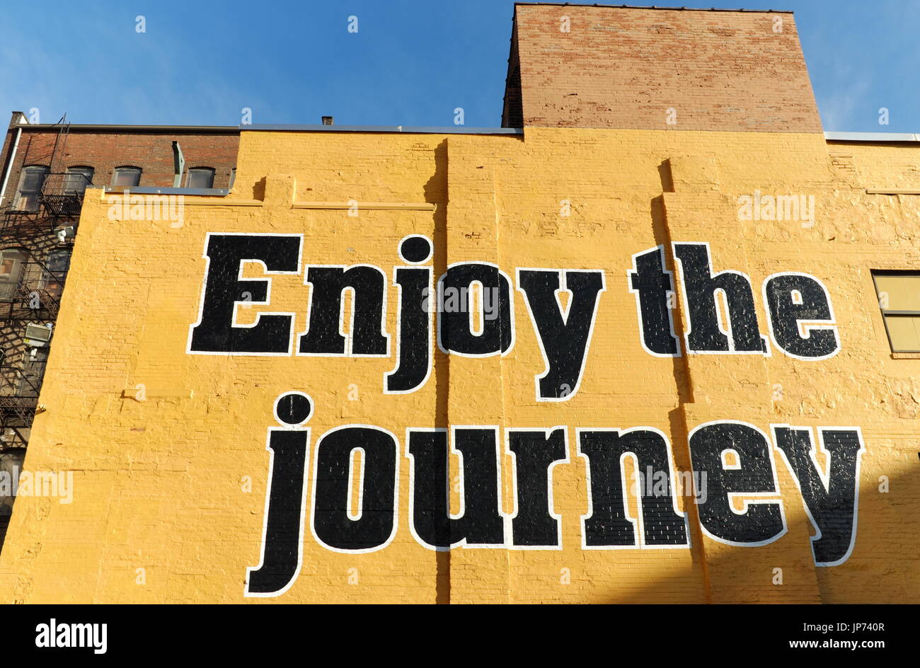 "Godetevi il viaggio" è dipinta su un muro nel centro di Cleveland, Ohio, USA come parte di una campagna PR per Akron-Canton aeroporto regionale. Foto Stock