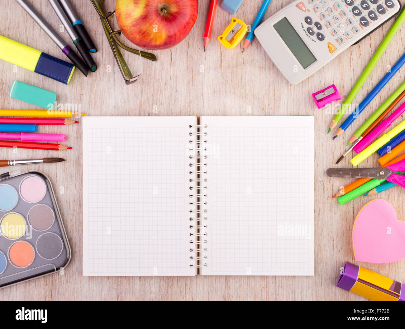 Vista dall'alto di aprire il notebook vuota sulla scrivania in legno con forniture scolastiche intorno a. Istruzione e creatività concetto Foto Stock