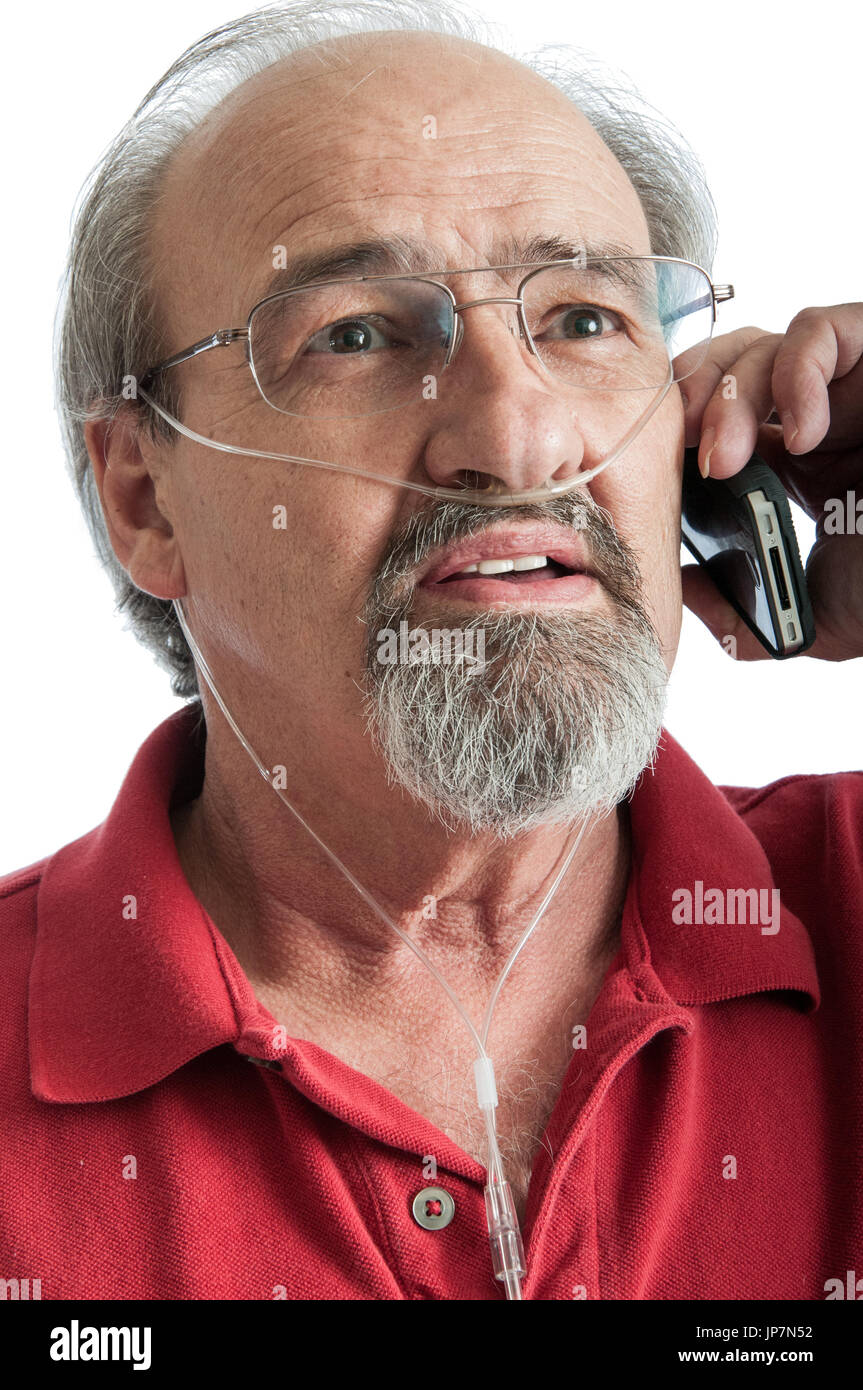 L'uomo anziano con BPCO a parlare al telefono mentre si indossa una cannula di ossigeno per aria supplementare. Foto Stock